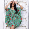 a woman standing in front of a white wall in a xmas kaftan